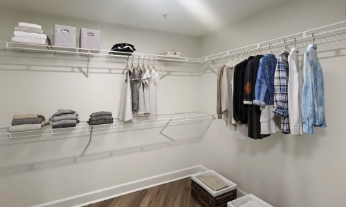 a closet with clothes hanging and shelves