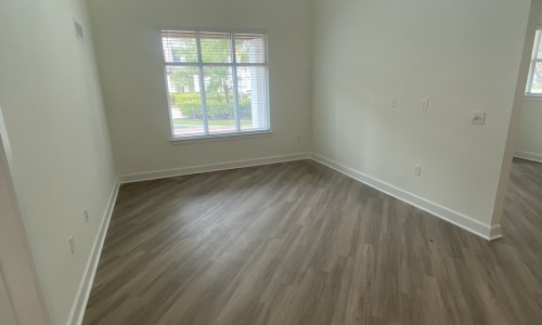 a room with white walls and a large window