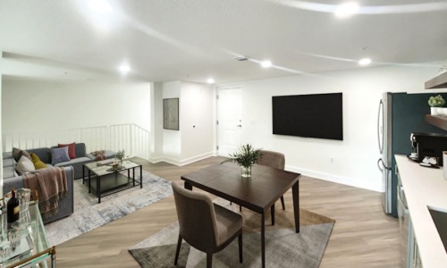 kitchen and living area with a table and chairs and a tv on the wall